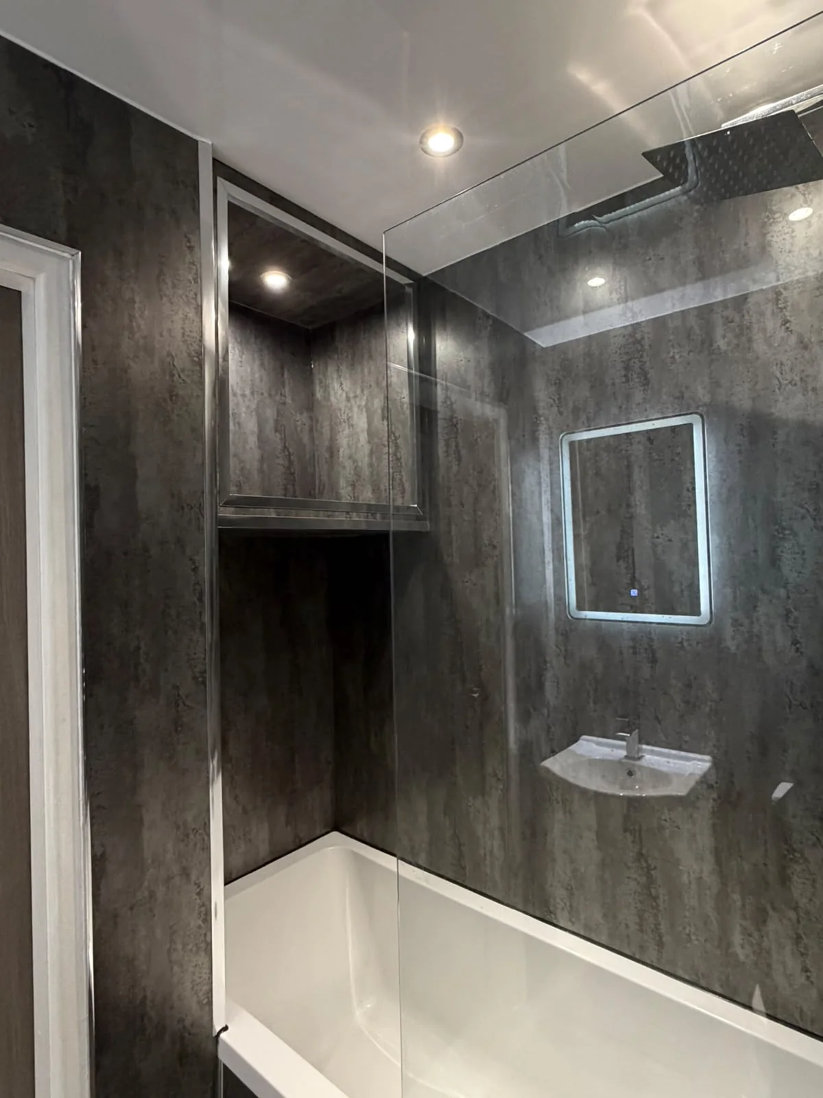 Bath and shower installation in a dark modern bathroom
